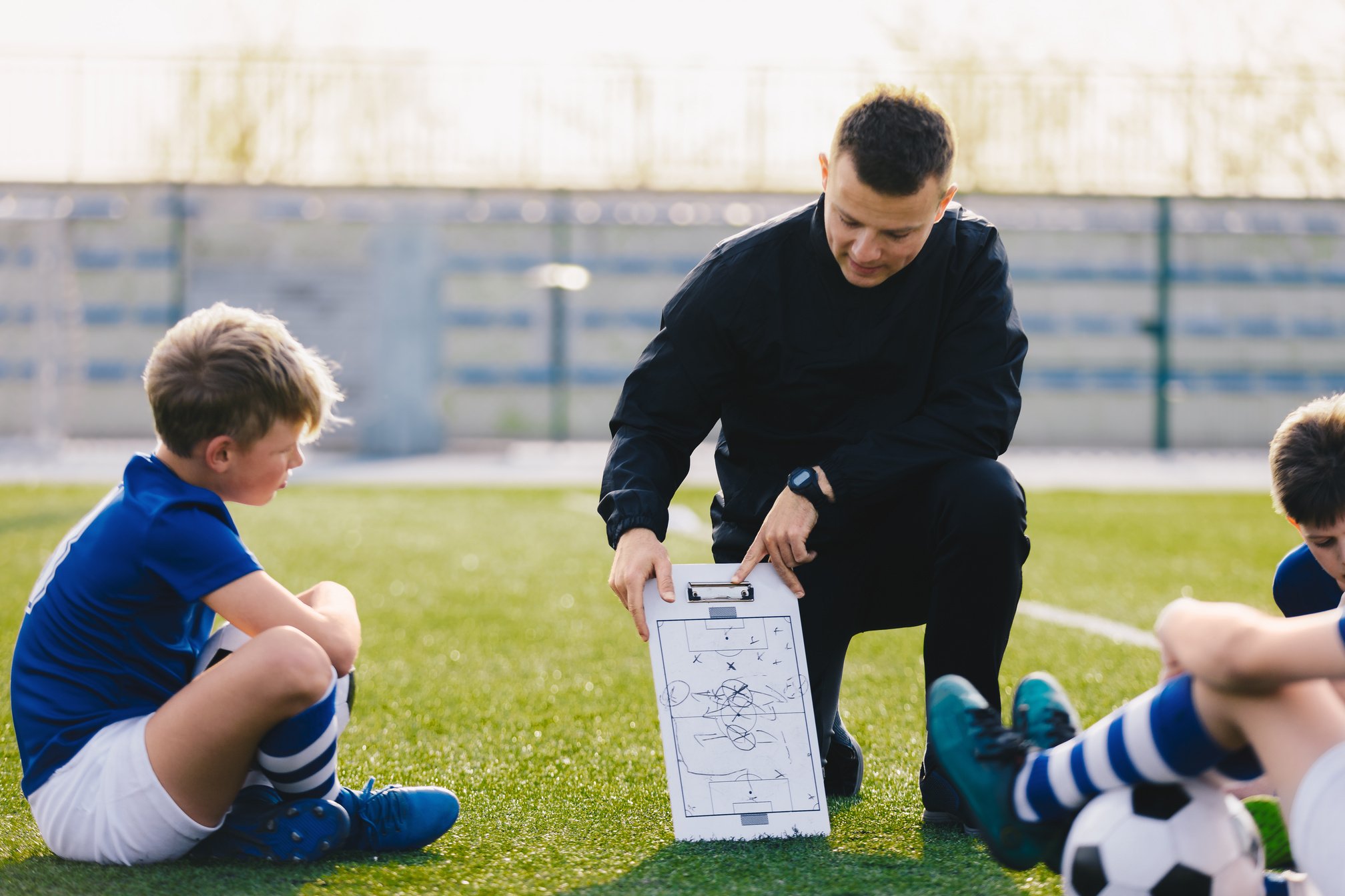 Young Soccer Trainer Coach Explaining Tactic on Team Sports Tact